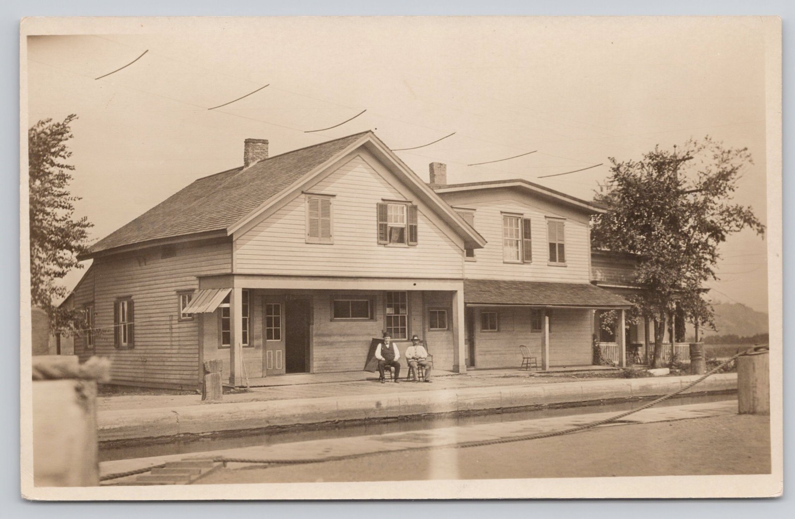 RPPC Unidentified Location & Men Sitting in Front of Building 1904-1918 Postcard