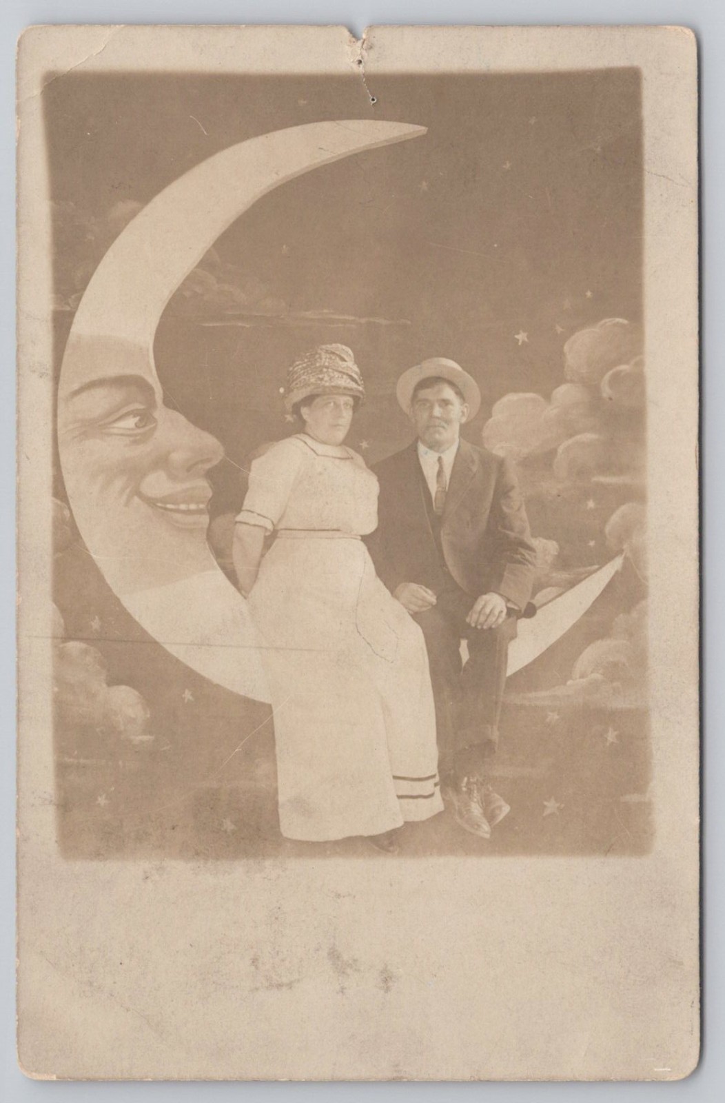 Portrait of Couple Sitting on Anthropomorphic Paper Moon RPPC UNP Postcard