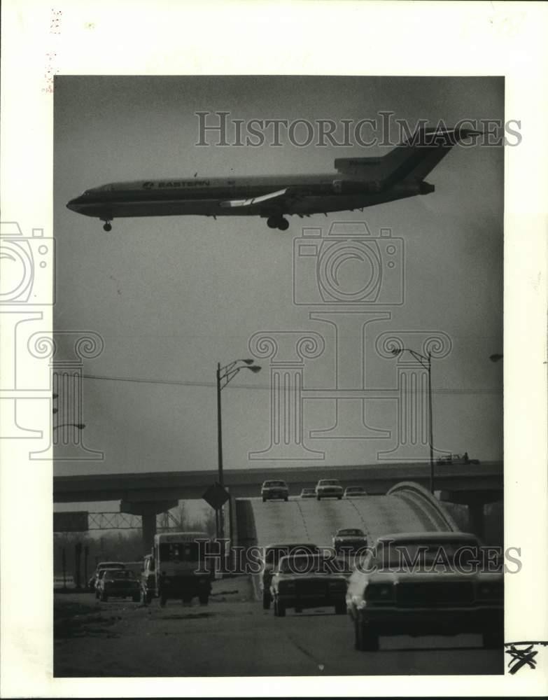 1979 Press Photo Airliner cruises over Interstate 10 span that links airport