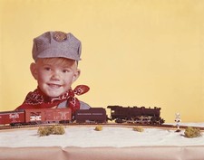 Boy standing by miniature train smiling Historic 1960s Old Photo picture